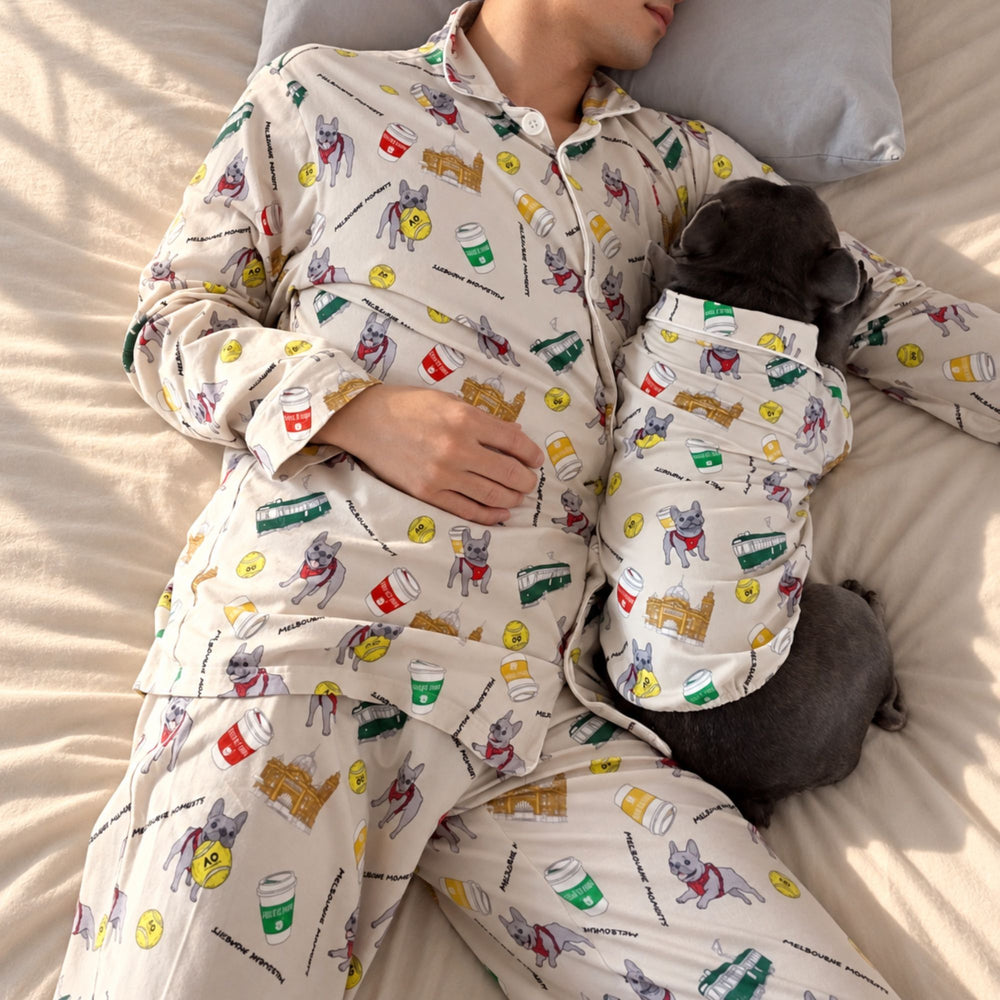 ベッドで眠る人と愛犬。Melbourne Daysのパジャマ（クリーム）を着ている